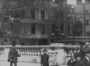 Framegrab from Easter Rising, Dublin 1916 (IWM 194) showing newsboys selling the Irish Times of 3 May 1916 against the ruins of Eden Quay.